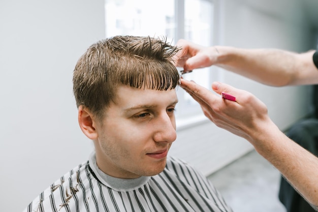 Portrait of young customer in barberop on haircut