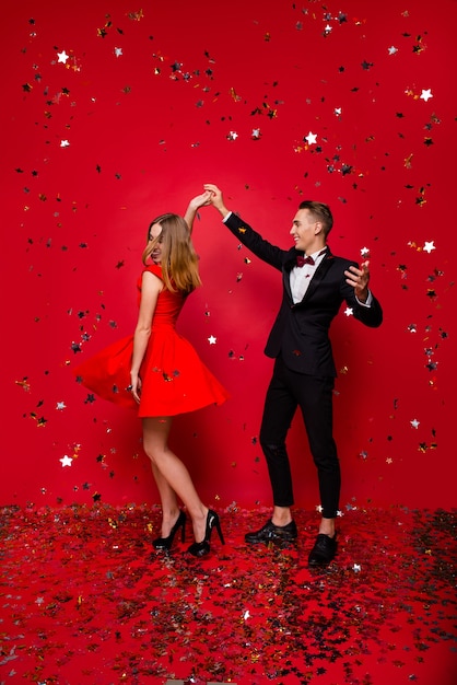 Portrait of young cute couple on a red background