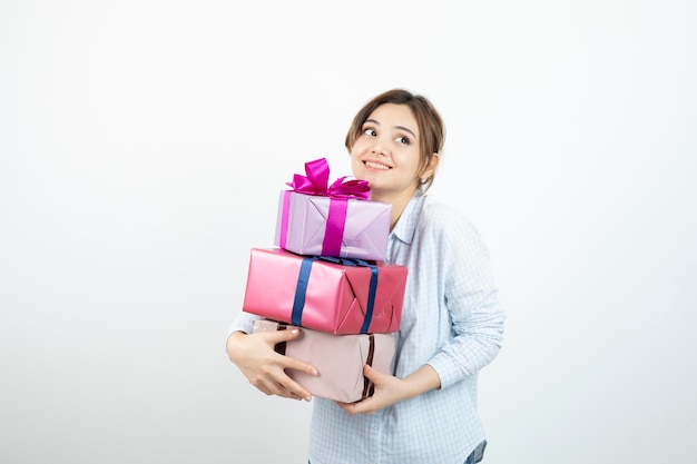 Portrait of a young cute girl holding present box with ribbon. High quality photo