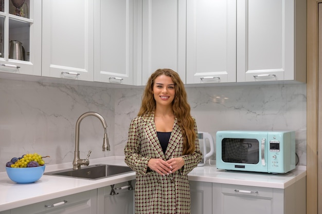 Portrait of young cute housewife in the kitchen interior