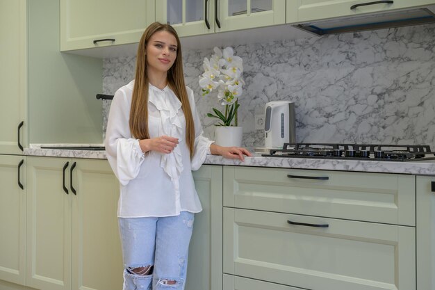 Portrait of young cute housewife in the kitchen interior