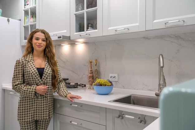 Portrait of young cute housewife in the kitchen interior