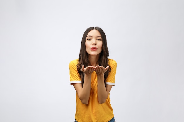 Portrait of a young cute woman blowing kiss at camera