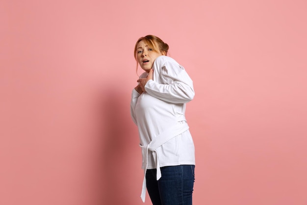 Portrait of young emotive girl with shocked expression posing isolated over pink background