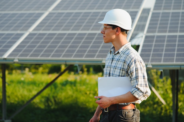 The portrait of a young engineer checks photovoltaic solar panels 