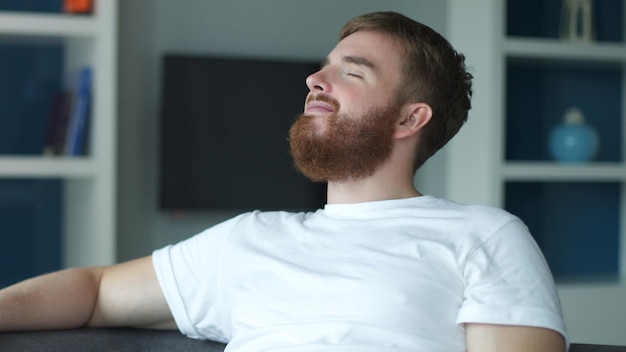 Portrait young european beard pensive thoughtful relaxed lonely guy man is dreaming thinking relax