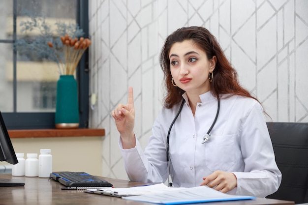 Portrait of young female health care worker and raised her finger to listen carefully High quality photo