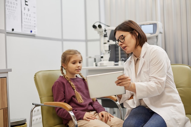 Portrait of young female ophthalmologist using digital tablet