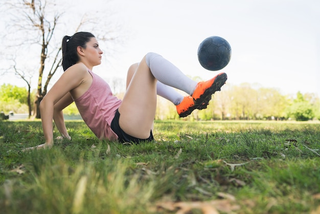 Portrait of young female soccer player training and practicing skills on football field. Sports concept.