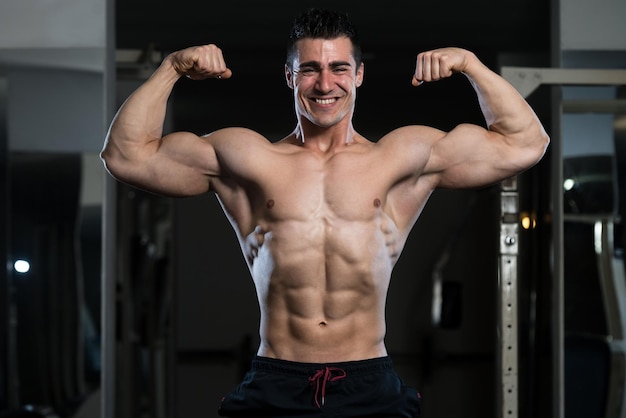 Portrait Of A Young Fit Man Showing Front Double Biceps Pose  Muscular Athletic Bodybuilder Fitness Model Posing