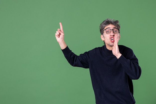 Portrait of young genius man dressed casually in studio shot on green wall