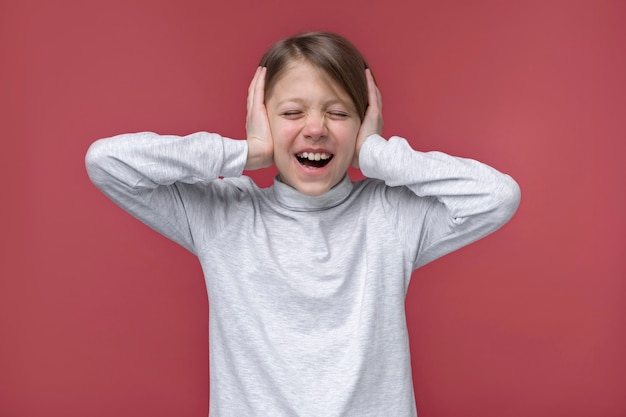 Portrait of young girl covering her ears