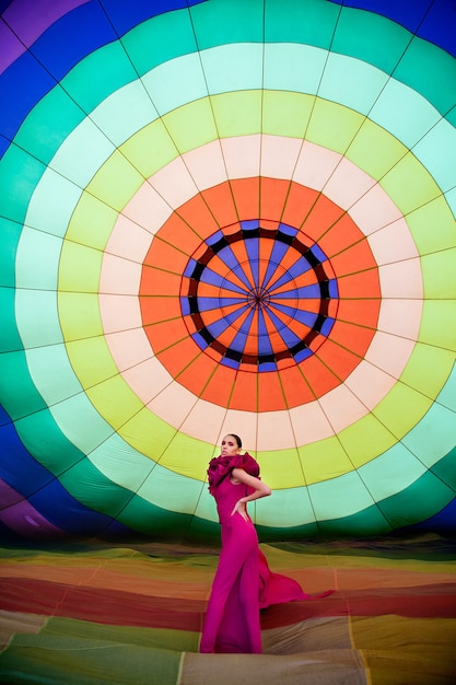 Portrait of a young girl in a crimson dress with a aerostat