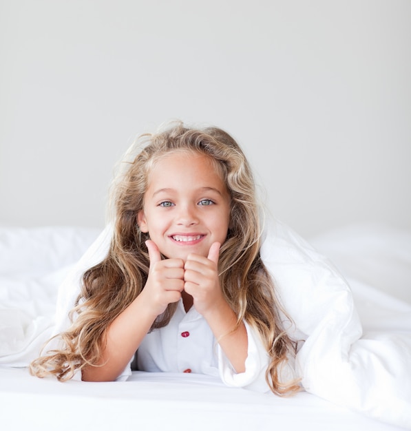 Portrait of a young girl lying on a bed