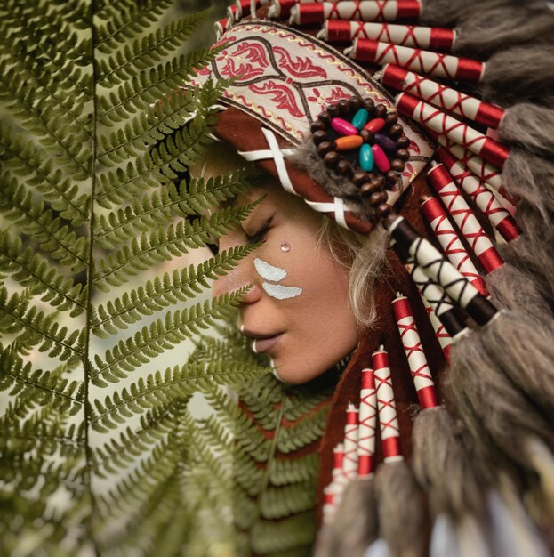 portrait of a young girl in Native American Headdresses against the background of nature