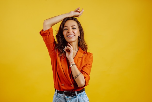 Portrait of young girl posing on yellow.