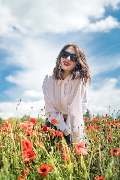 Portrait of young girl at the red poppies field. enjoy spending time at nature