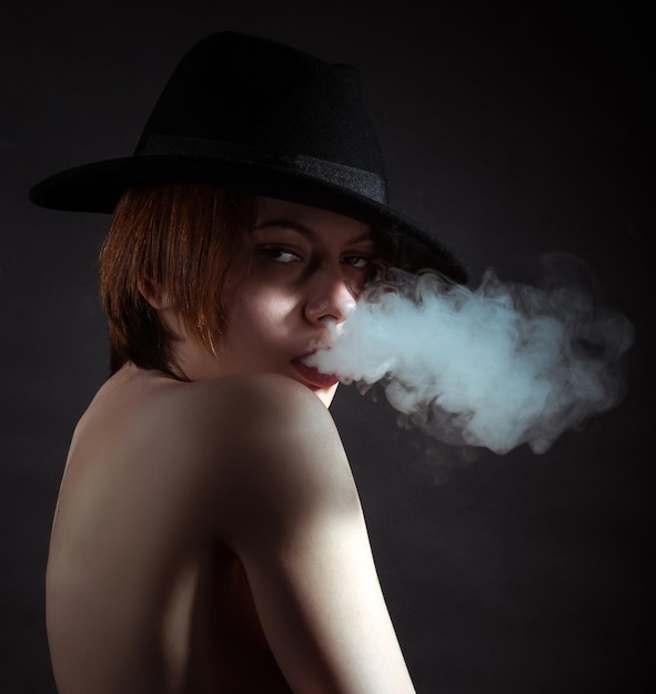 Portrait of a young girl in the smoke of cigarettes