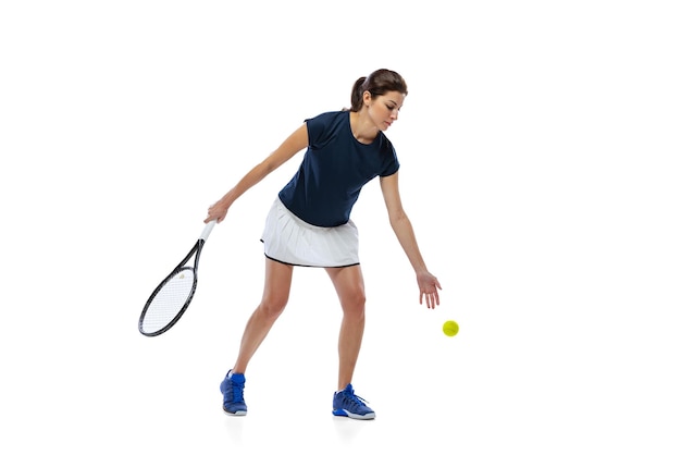 Portrait of young girl tennis player training isolated over white studio background Ball serving