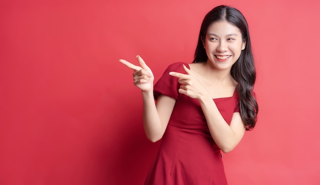 Portrait of young girl wearing red dress with expression on background