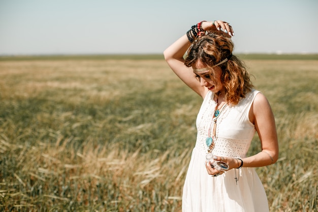 Portrait of a young girl in a white translucent dress in boho or hippie style