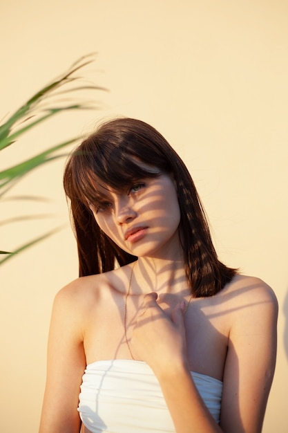 Portrait of a young girl with brown hair square with a shadow from a branch