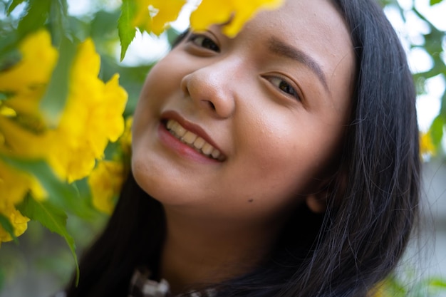 Portrait young girl with yellow flowers Asian girl