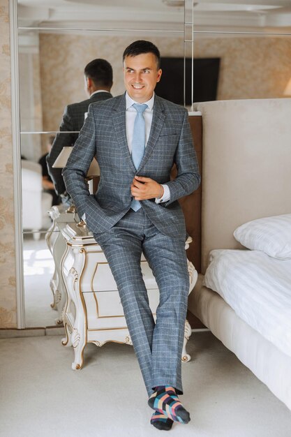 Portrait of a young groom at home before the wedding ceremony A handsome man dressed in a classic suit Male portrait