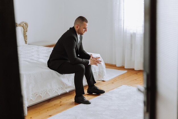 Portrait of a young groom at home before the wedding ceremony A handsome man dressed in a classic suit Male portrait