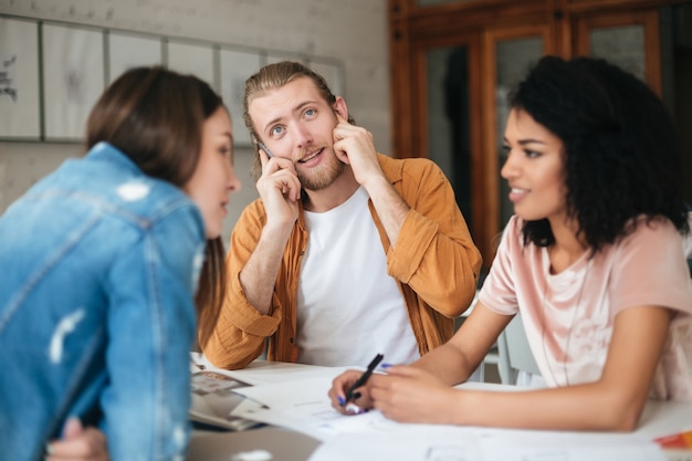 Portrait of young group of people working together in office