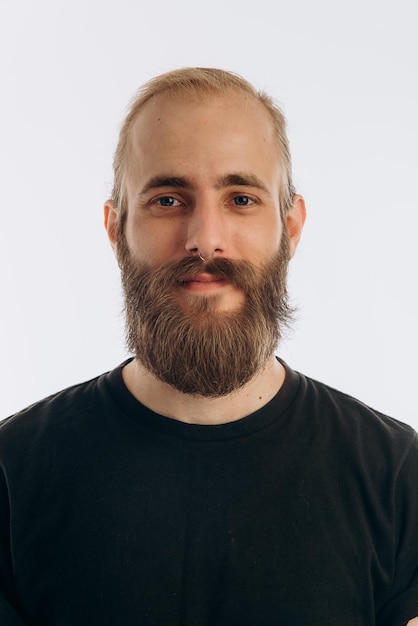 Portrait of a young guy with a beard in a black Tshirt on a white background hipster