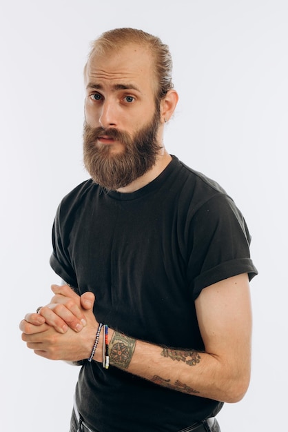 Portrait of a young guy with a beard in a black Tshirt on a white background hipster