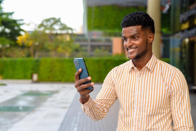 Portrait of young handsome African businessman wearing stylish clothes