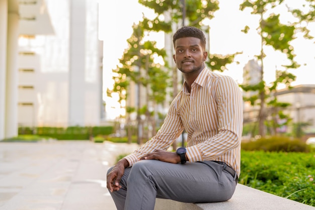 Portrait of young handsome African businessman wearing stylish clothes