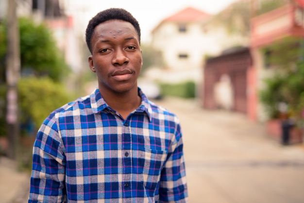 Portrait of young handsome African man in the streets outdoors