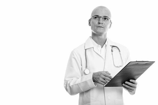 Portrait of young handsome bald man doctor isolated on white in black and white