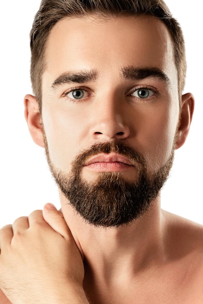 Portrait of young and handsome bearded man with smooth skin on white background