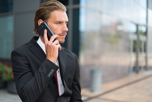 Portrait of a young handsome businessman talking on his mobile phone