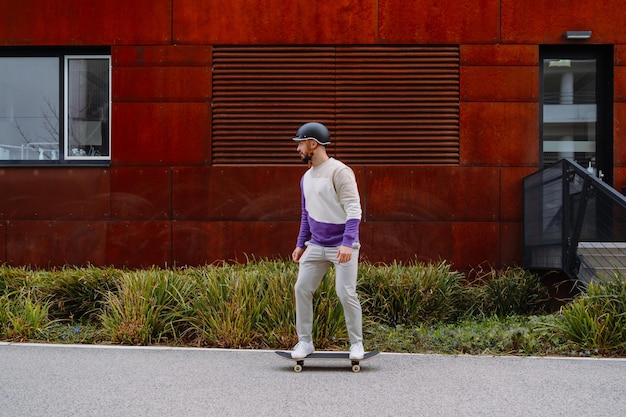 Portrait of young handsome guy with skateboard Urban Industrial background High quality photo