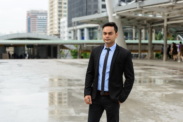 Portrait of young handsome Indian businessman in the city