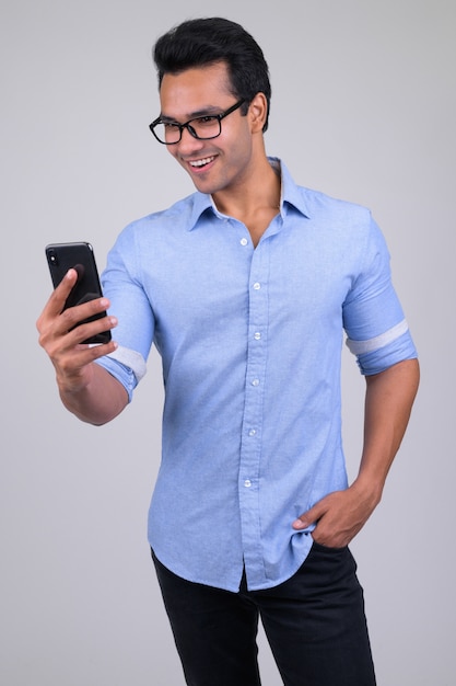 Portrait of young handsome Indian businessman on white