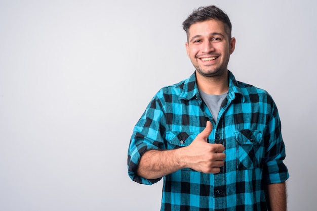 Portrait of young handsome Iranian hipster man on white