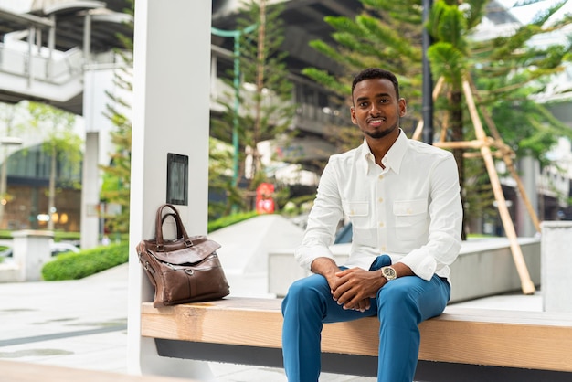 Portrait of young handsome stylish black man in city