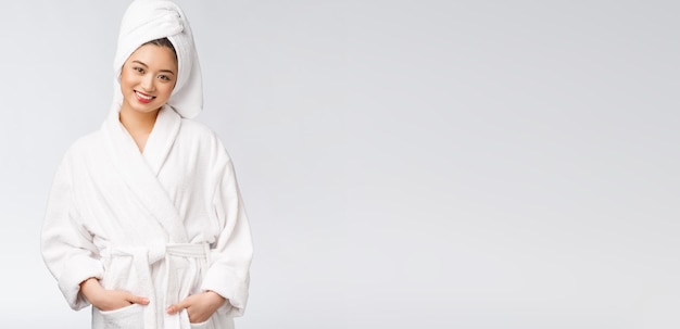 Portrait of a young happy asian lady in bathrobeIsolated in white background