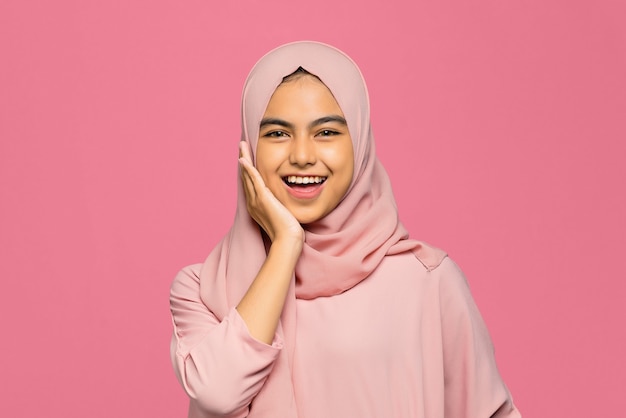 Portrait of young happy Asian woman laughs and touches the cheek