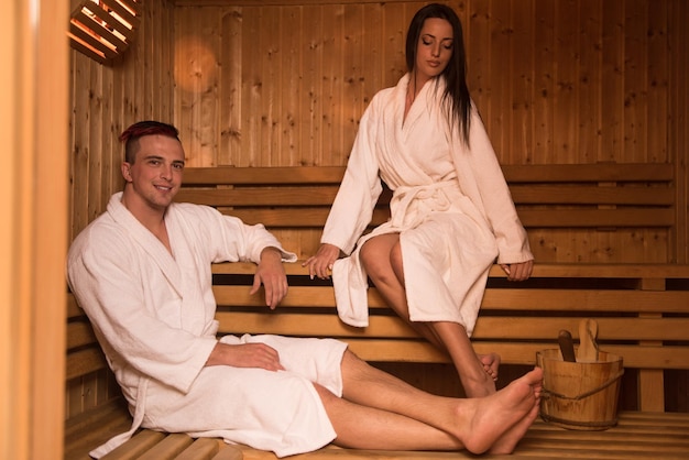 Portrait of a young happy beautiful couple enjoys relaxing in the sauna