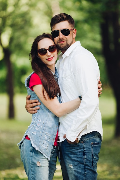 Portrait of young happy couple in love, smiling and embracing in garden