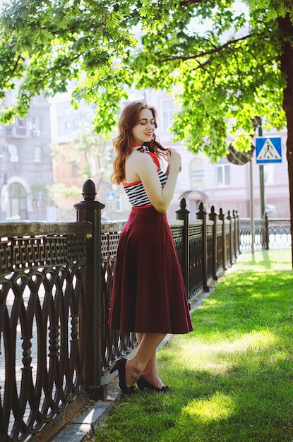 portrait of young, happy,  elegant redhead curly woman, girl in hat and casual clothes. French style