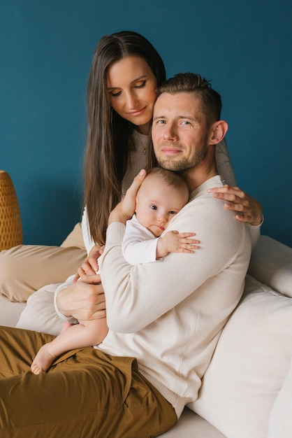 Portrait of a young happy family with a child in a cozy house