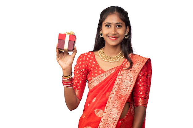 Portrait of young happy smiling Girl holding gift box on a white background